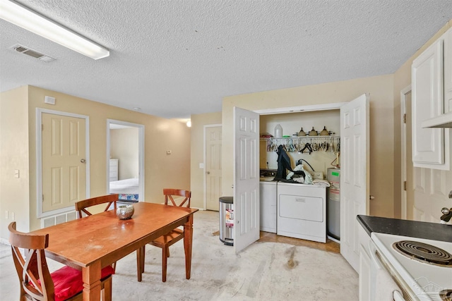 dining space featuring a textured ceiling, washing machine and dryer, and electric water heater