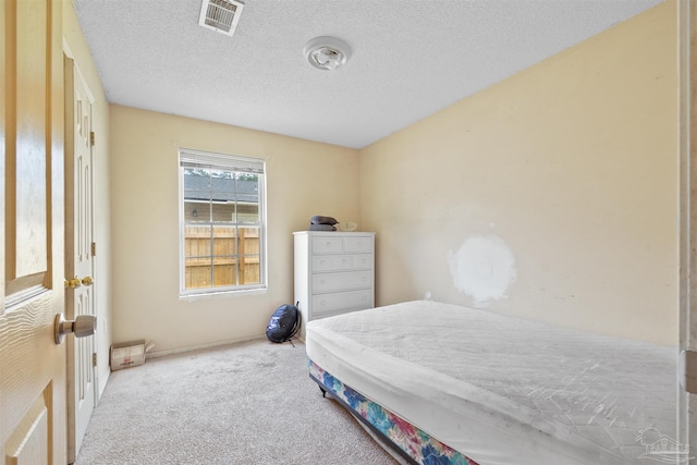 carpeted bedroom featuring a textured ceiling