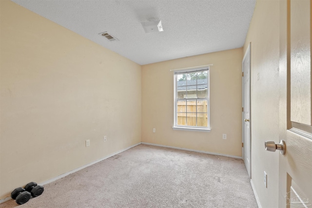 carpeted spare room featuring a textured ceiling