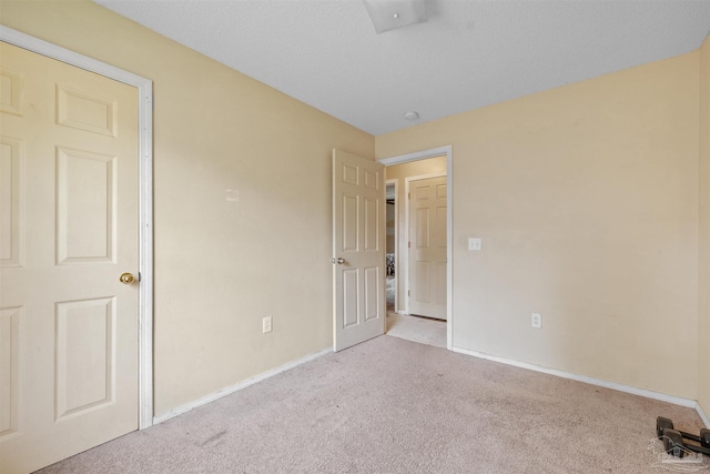 carpeted spare room featuring a textured ceiling