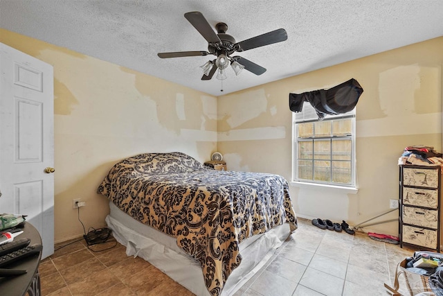 tiled bedroom with ceiling fan and a textured ceiling