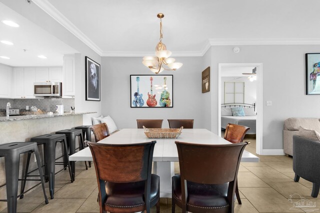 tiled dining room with crown molding and ceiling fan with notable chandelier