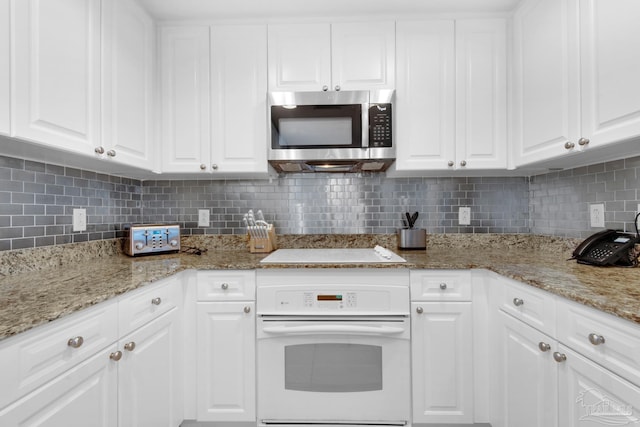 kitchen featuring white cabinetry, white appliances, and decorative backsplash