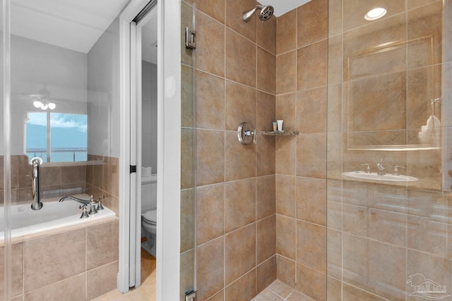 bathroom featuring plus walk in shower, ceiling fan, and toilet