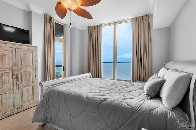 tiled bedroom featuring multiple windows, crown molding, ceiling fan, and a water view