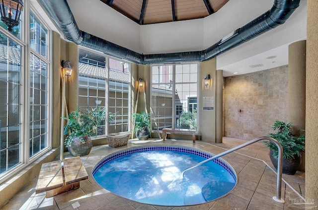 view of swimming pool with an indoor hot tub