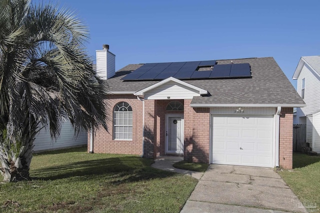 view of front of property featuring a front lawn, a garage, and solar panels