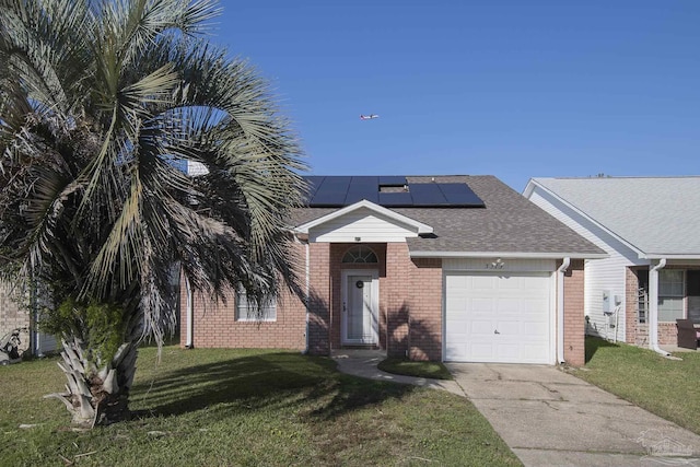 view of front of house featuring solar panels, a garage, and a front lawn