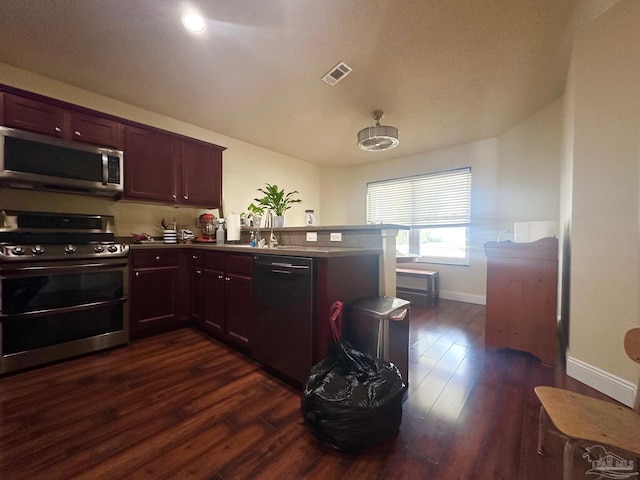 4955 Makenna Cir, Pace, FL 32571 - kitchen featuring appliances with stainless steel finishes, a peninsula, dark wood finished floors, baseboards, and dark countertops