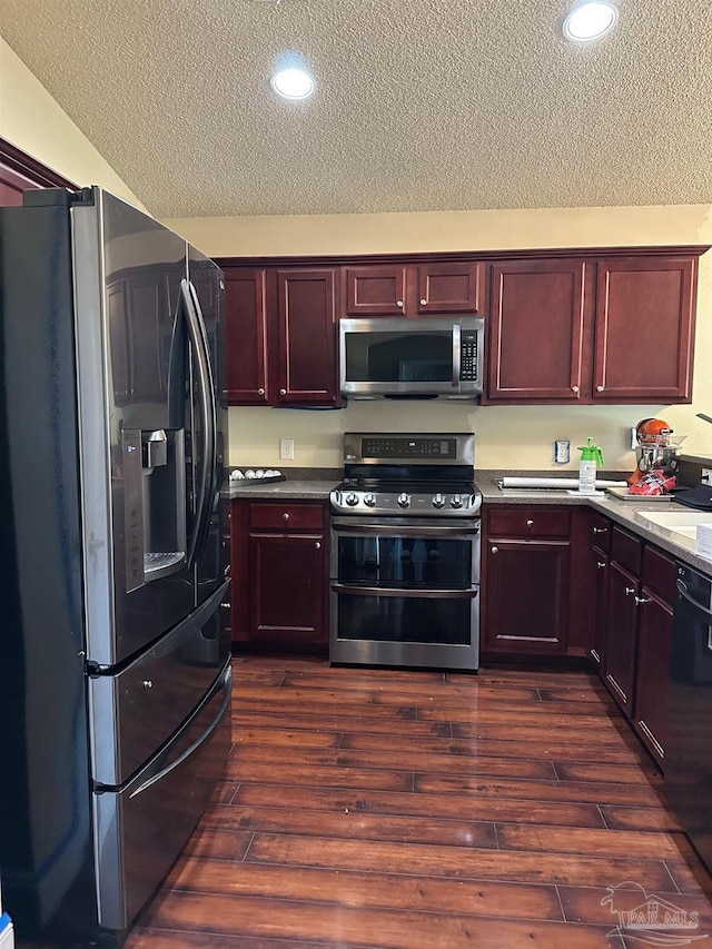 4955 Makenna Cir, Pace, FL 32571 - kitchen featuring stainless steel appliances, reddish brown cabinets, a textured ceiling, dark wood-type flooring, and recessed lighting