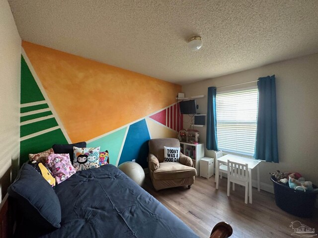 4955 Makenna Cir, Pace, FL 32571 - bedroom featuring wood finished floors and a textured ceiling