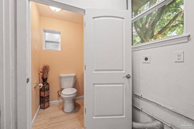 bathroom featuring baseboards, toilet, and wood finished floors