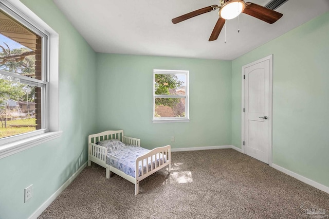 carpeted bedroom featuring baseboards and a ceiling fan