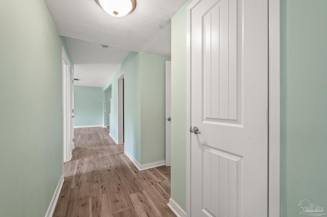 hall featuring baseboards and wood finished floors