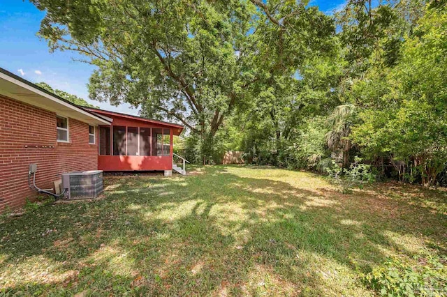 view of yard featuring a sunroom, central air condition unit, and fence