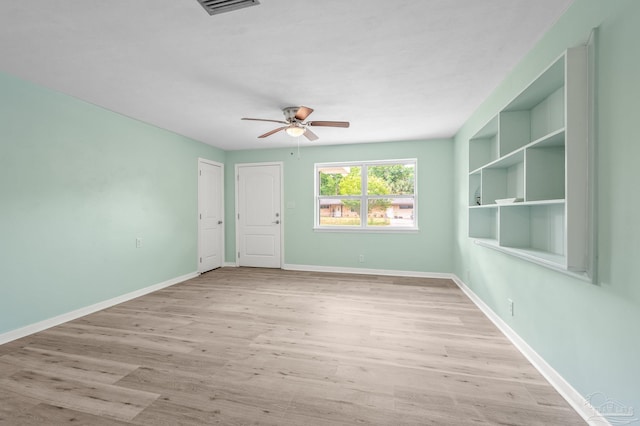 unfurnished room with baseboards, ceiling fan, wood finished floors, and visible vents