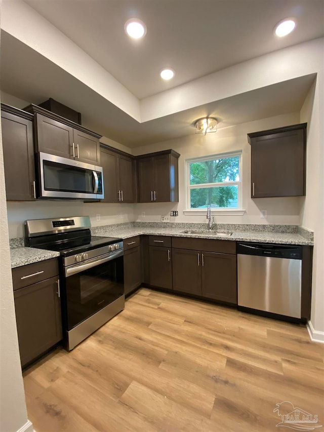 kitchen featuring light wood-type flooring, appliances with stainless steel finishes, and sink