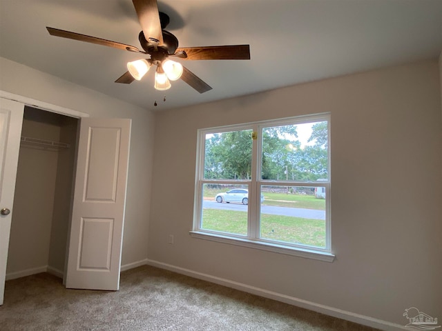 unfurnished bedroom with a closet, light colored carpet, and ceiling fan