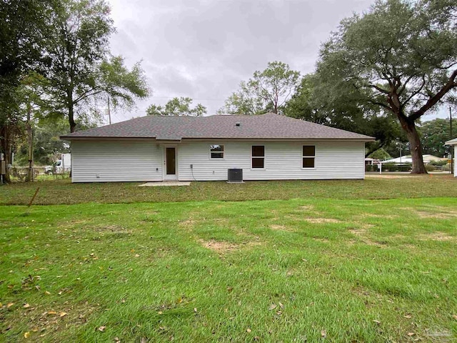 rear view of house with a yard and cooling unit