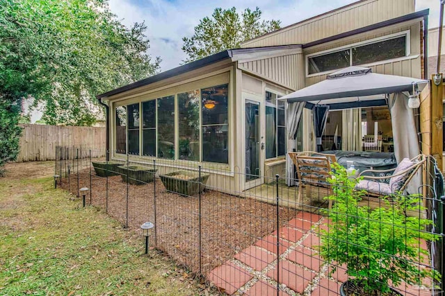 view of home's exterior featuring a sunroom and a gazebo