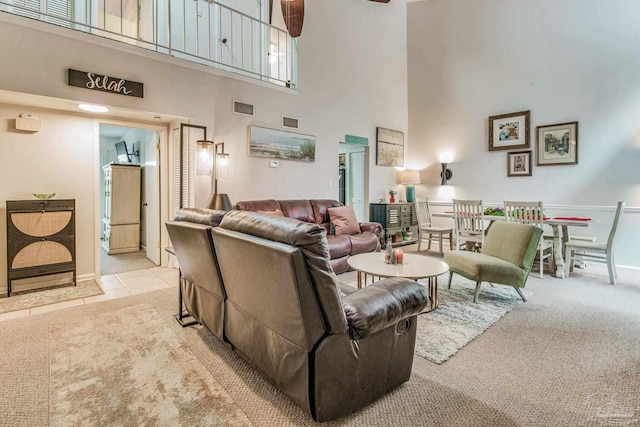 carpeted living room with a high ceiling