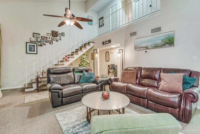 carpeted living room featuring a high ceiling and ceiling fan