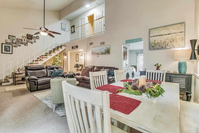 dining space with high vaulted ceiling, light colored carpet, and ceiling fan