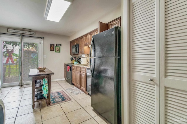 kitchen with black appliances and light tile patterned floors