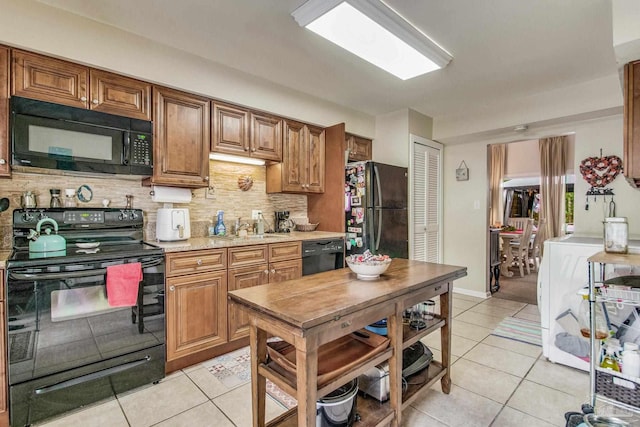 kitchen featuring black appliances, light tile patterned floors, tasteful backsplash, and sink