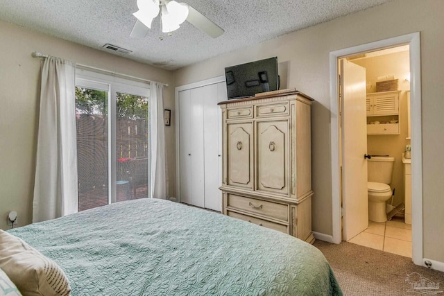 bedroom featuring a textured ceiling, light carpet, ceiling fan, and connected bathroom