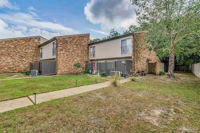 rear view of property with a yard and cooling unit