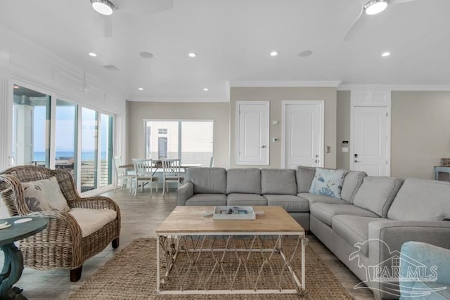 living room featuring ceiling fan, light hardwood / wood-style flooring, and ornamental molding