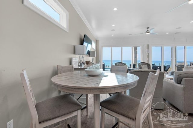 dining space featuring hardwood / wood-style floors, crown molding, ceiling fan, and a healthy amount of sunlight