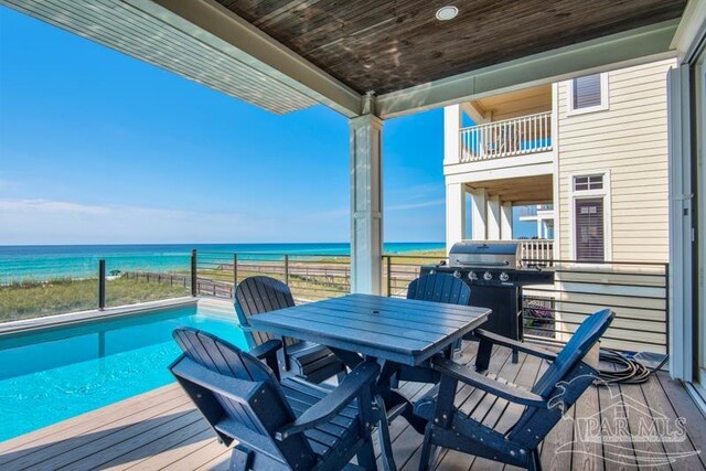 exterior space with a balcony, grilling area, and a water view