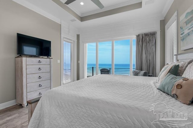 bedroom with light hardwood / wood-style flooring, access to exterior, a tray ceiling, ceiling fan, and ornamental molding