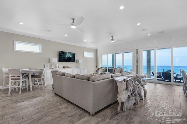 living room featuring plenty of natural light, ceiling fan, and light hardwood / wood-style flooring