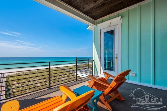 balcony with a water view and a beach view