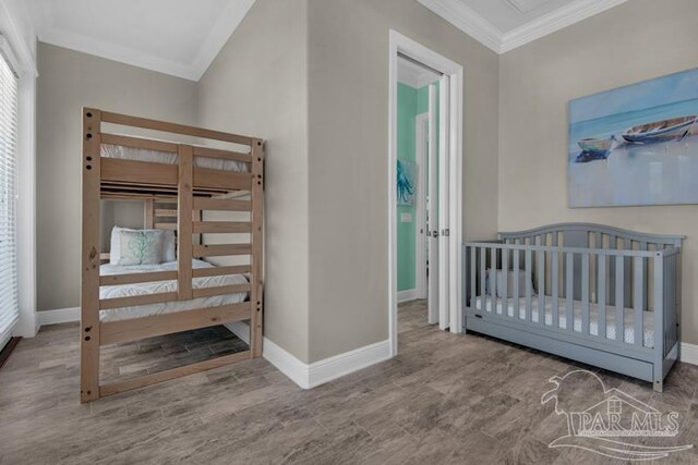 bedroom with ornamental molding and wood-type flooring