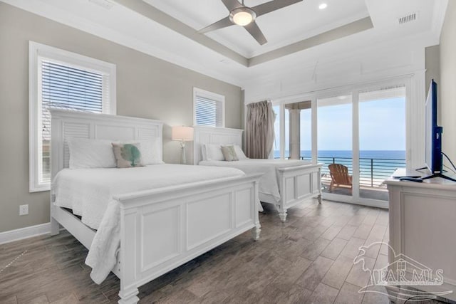 bedroom with crown molding, ceiling fan, wood-type flooring, and a raised ceiling