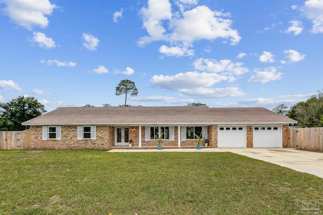 single story home featuring an attached garage, fence, concrete driveway, french doors, and a front lawn