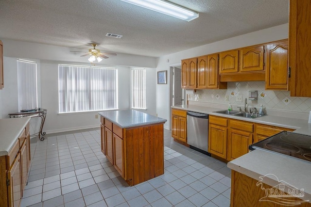 kitchen with sink, backsplash, a center island, ceiling fan, and stainless steel dishwasher