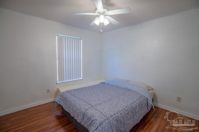 bedroom with dark hardwood / wood-style flooring and ceiling fan