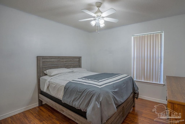 bedroom featuring dark hardwood / wood-style flooring, a textured ceiling, and ceiling fan