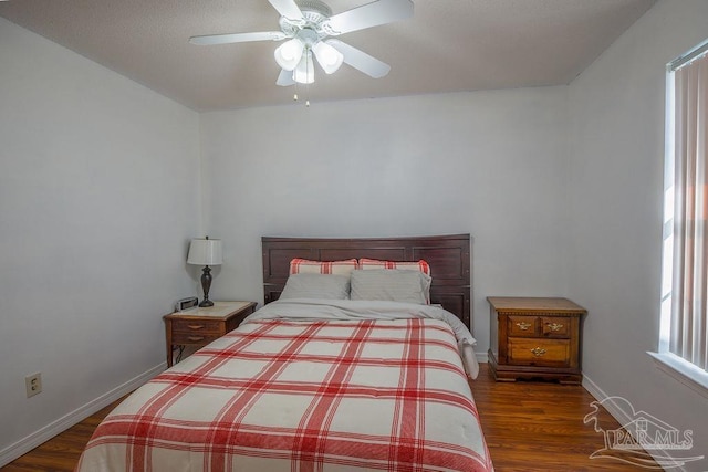 bedroom with ceiling fan, multiple windows, and dark hardwood / wood-style floors