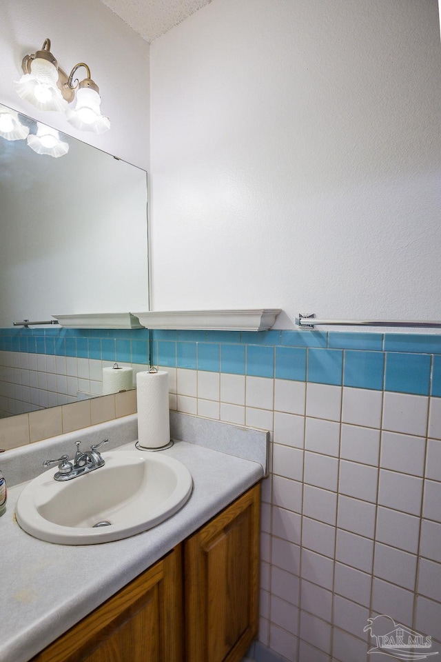 bathroom with vanity, a textured ceiling, and tile walls