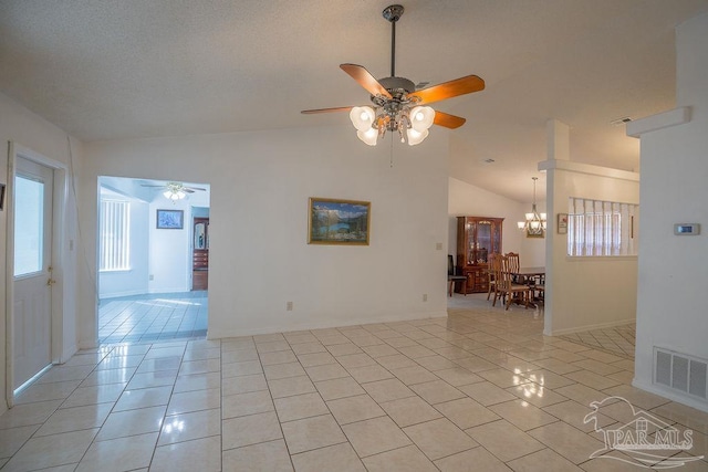 tiled spare room featuring high vaulted ceiling and ceiling fan with notable chandelier