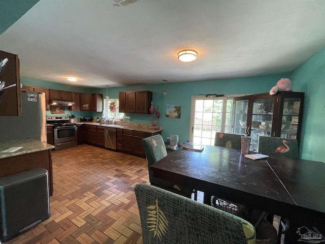 1695 Beechwood Dr, Gulf Breeze, FL 32563 - kitchen featuring under cabinet range hood, stainless steel appliances, light countertops, and plenty of natural light