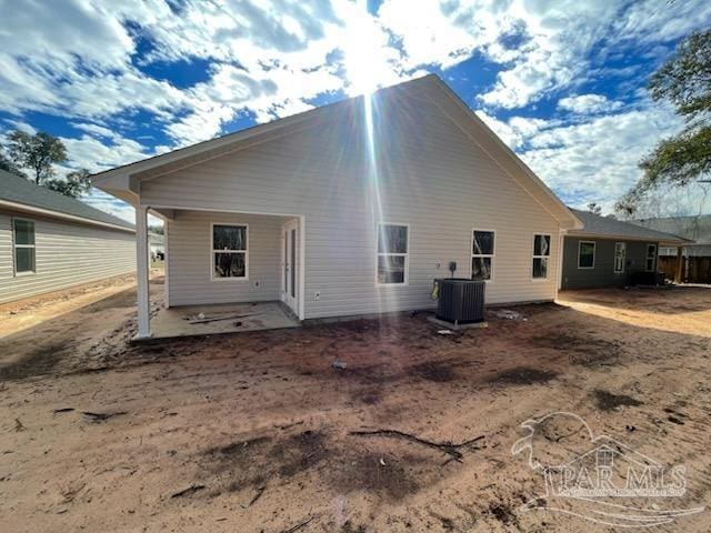 back of property with central AC and a patio