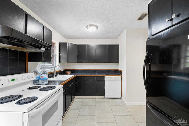 kitchen featuring sink, a textured ceiling, light tile patterned floors, white appliances, and exhaust hood