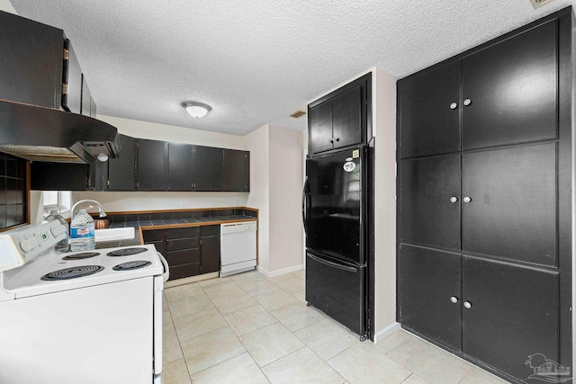 kitchen with white appliances, sink, a textured ceiling, and light tile patterned floors